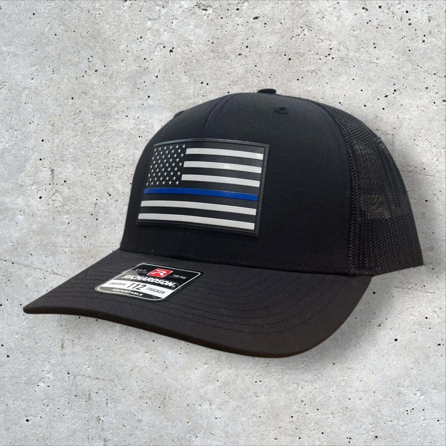 Thin Blue Line Hat featuring a UV-printed American flag patch on a black Richardson 112 trucker cap.